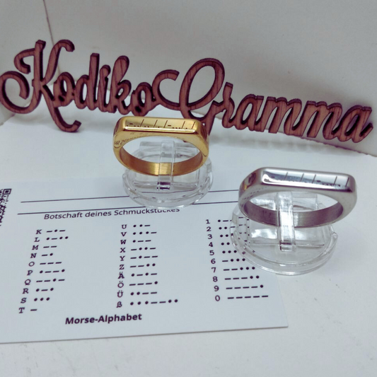 Gold- und Silberring „Liebe“ mit Morsecode, verpackt in Geschenkbox mit Entschlüsselungstabelle.